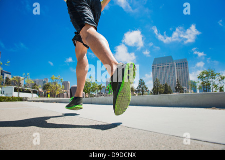 Young man jogging in city, low section Stock Photo