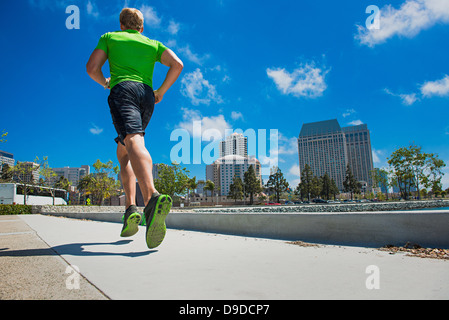 Young man jogging in city, rear view Stock Photo