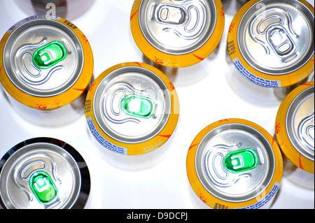 The tops of a variety of cans of fizzy pop photographed against a white background. Stock Photo