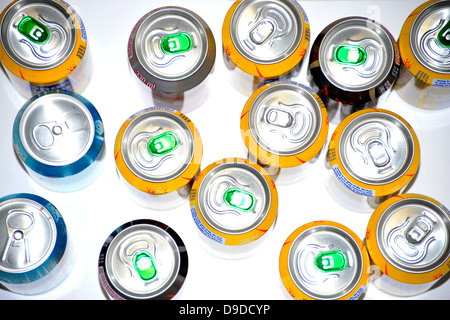 The tops of a variety of cans of fizzy pop photographed against a white background. Stock Photo