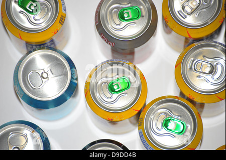 The tops of a variety of cans of fizzy pop photographed against a white background. Stock Photo