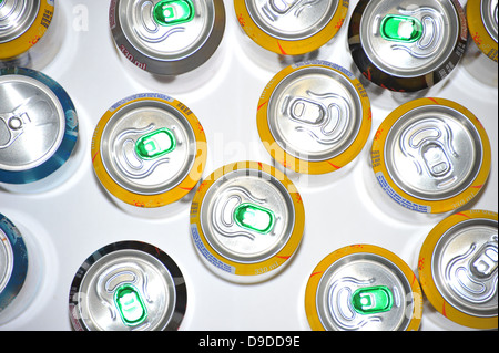 The tops of a variety of cans of fizzy pop photographed against a white background. Stock Photo