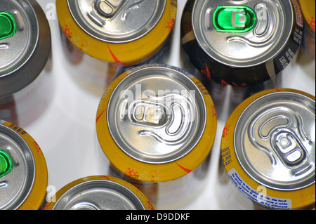 The tops of a variety of cans of fizzy pop photographed against a white background. Stock Photo