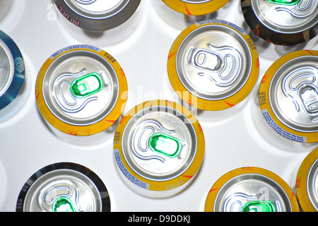 The tops of a variety of cans of fizzy pop photographed against a white background. Stock Photo