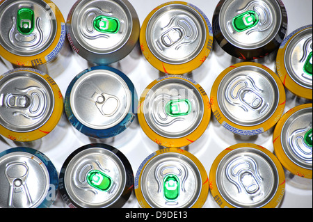 The tops of a variety of cans of fizzy pop photographed against a white background. Stock Photo