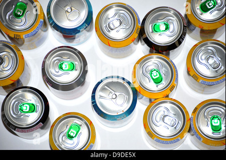 The tops of a variety of cans of fizzy pop photographed against a white background. Stock Photo