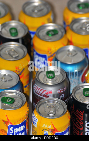 The tops of a variety of cans of fizzy pop photographed against a white background. Stock Photo