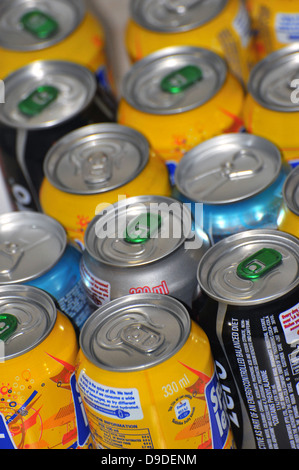 The tops of a variety of cans of fizzy pop photographed against a white background. Stock Photo