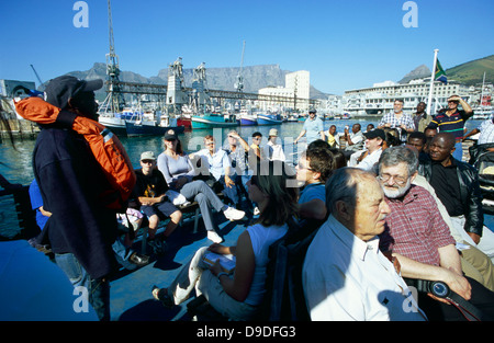 A tour guide addresses tourists on the deck of a ferry bound for Robben Island Stock Photo