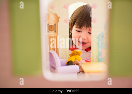 Girl playing with doll house Stock Photo