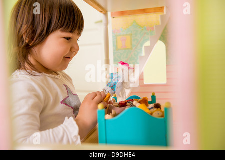 Girl playing with doll house Stock Photo