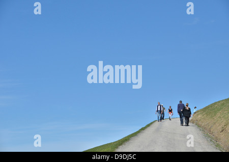 People walking on a hillside path Stock Photo
