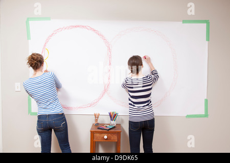 Girls drawing on wall Stock Photo