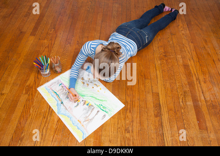 Girl lying on floor drawing picture Stock Photo