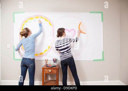 Girls drawing on wall Stock Photo