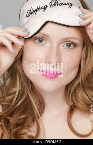 Teenage girl wearing Sleeping Beauty eye mask on head Stock Photo