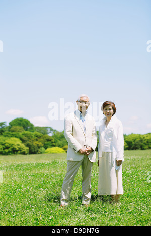 Senior couple on grassland smiling at camera Stock Photo