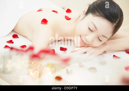 Woman covered in rose petals Stock Photo