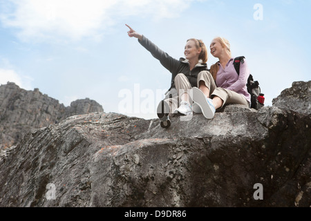 Portrait of two girl hikers sitting on rock formation Stock Photo