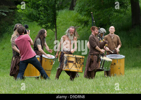 Kelvingrove Park, Glasgow, Scotland, UK, 18th June 2013. Big Peat Drums and Bagpipes traditional Scottish band play music for the locals while recording a new video. Big Peat can usually be seen in Buchanan Street in Glasgow and are quite a famous group. Paul Stewart/Alamy Live News Stock Photo