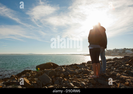 Young couple looking out to sea and horizon Stock Photo