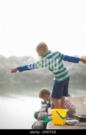 Two young boys fishing on pier Stock Photo