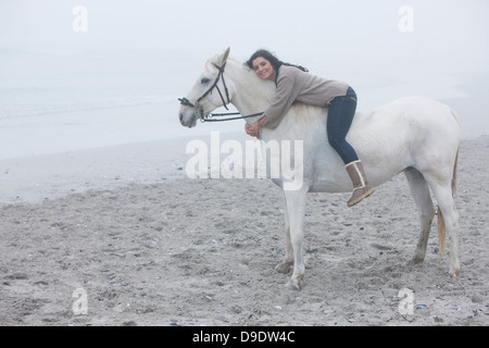 Woman riding horse on beach Stock Photo