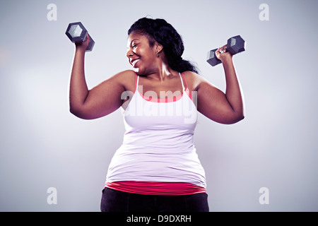 Mature woman using hand weights, smiling Stock Photo