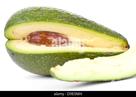 Whole avacado and slice closeup on white  Stock Photo