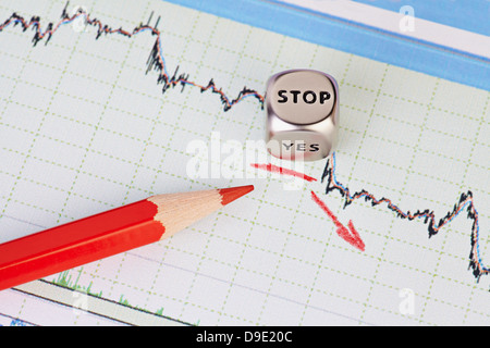 Downtrend financial market chart , red pencil, red arrow and dices cube with the word STOP. Selective focus Stock Photo