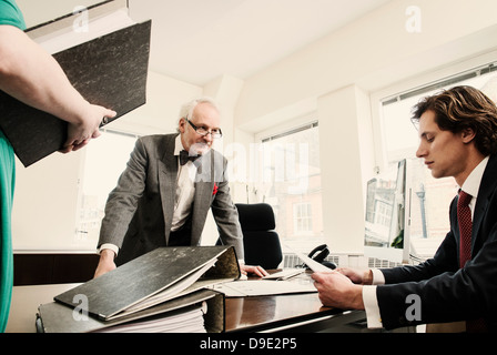 People in office with ring binders on desk Stock Photo