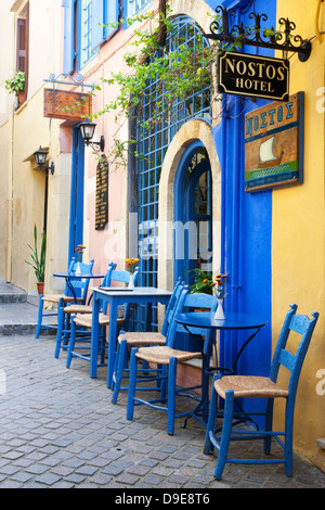 Small inviting cafe at Nostos Hotel with tables and chairs on an outdoor patio in old town Chania, Crete, Greece Stock Photo
