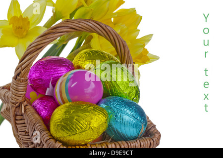 Small wicker basket with Easter eggs and daffodils isolated on white. Stock Photo