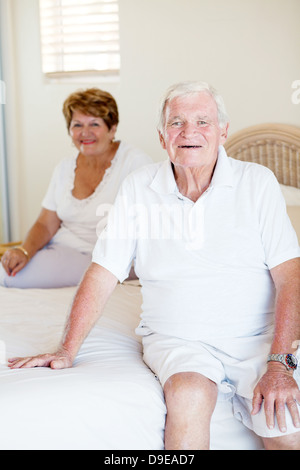 happy senior couple sitting on bed Stock Photo