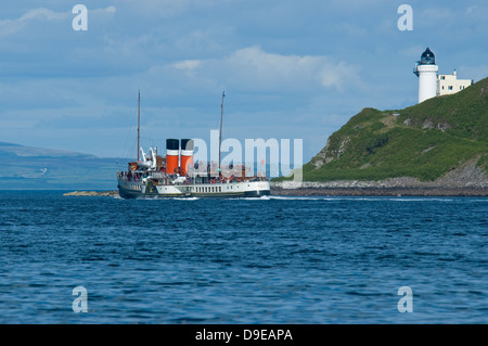 The Waverley the last sea going paddle steamer in the world on a pleasure excursion from Campbeltown passing a lighthouse. Stock Photo