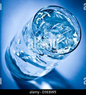 Glass of water with ice on a dark blue background Stock Photo - Alamy