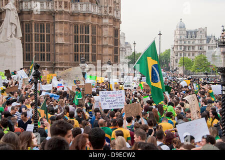 London, UK. 18th June 2013. Thousands of Brazilians waving Brazilian flags, banners and placards demonstrate at a protest outside the Houses of Parliament. Credit:  Pete Maclaine/Alamy Live News Stock Photo