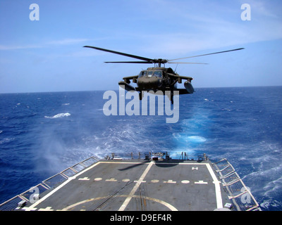 An Army UH-60 Black Hawk helicopter landing aboard the USS Underwood off the coast of Honduras. Stock Photo