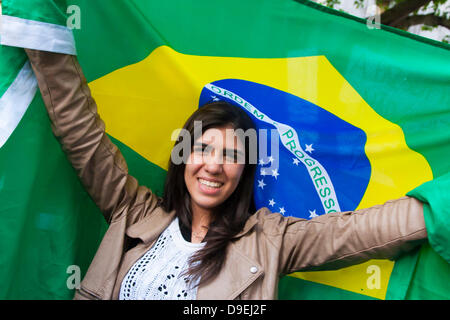 London, UK. 18th June, 2013. Thousands of Brazilians demonstrate outside the Brazilian embassy in London in solidarity with their compatriots who are protesting against increased transport charges, spiraling costs of Brazil 2014 and the Rio Olympics, at the expense of public services. Credit:  Paul Davey/Alamy Live News Stock Photo
