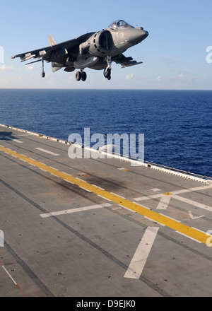 An AV-8B Harrier jet prepares to land on the flight deck of USS Essex. Stock Photo