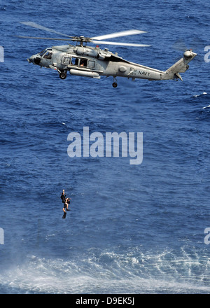 Search and rescue swimmers being hoisted into a helicopter. Stock Photo