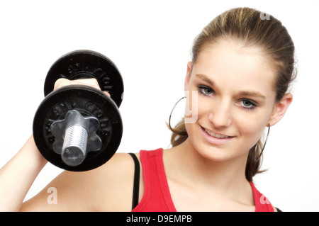 Young woman in the red sports top trains with a short dumbbell. (Model release) Stock Photo