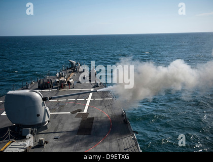 An Mk-45 lightweight gun is fired aboard guided missile destroyer USS Arleigh Burke. Stock Photo