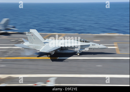 An F/A-18C Hornet lands aboard USS George H.W. Bush. Stock Photo