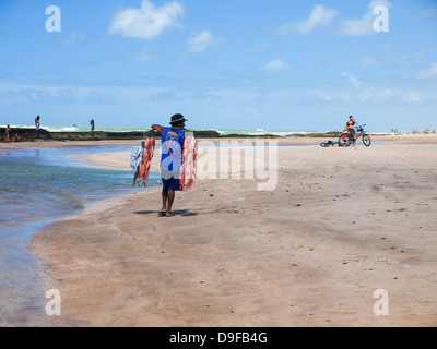 Fisherman walking with fish on his shoulders on a beach in Recife, Brazil. Stock Photo