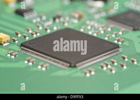 Detail of a circuit board with conductor tracks, resistors, and a computer chip Stock Photo