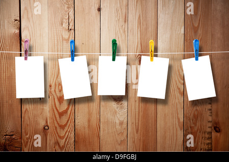 Blank picture frame hanging on clothesline on wood background Stock Photo