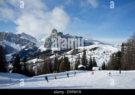Skiers at the Alta Badia ski resort with Sassongher Mountain in the distance, Dolomites, South Tyrol, Italy Stock Photo