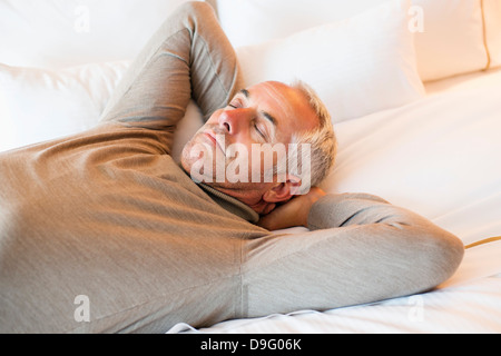 Man resting on the bed in a hotel room Stock Photo