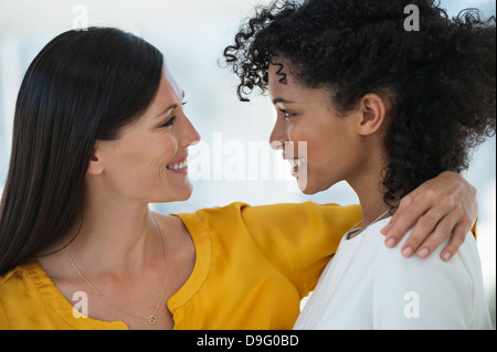 Close-up of two female friends smiling at each other Stock Photo